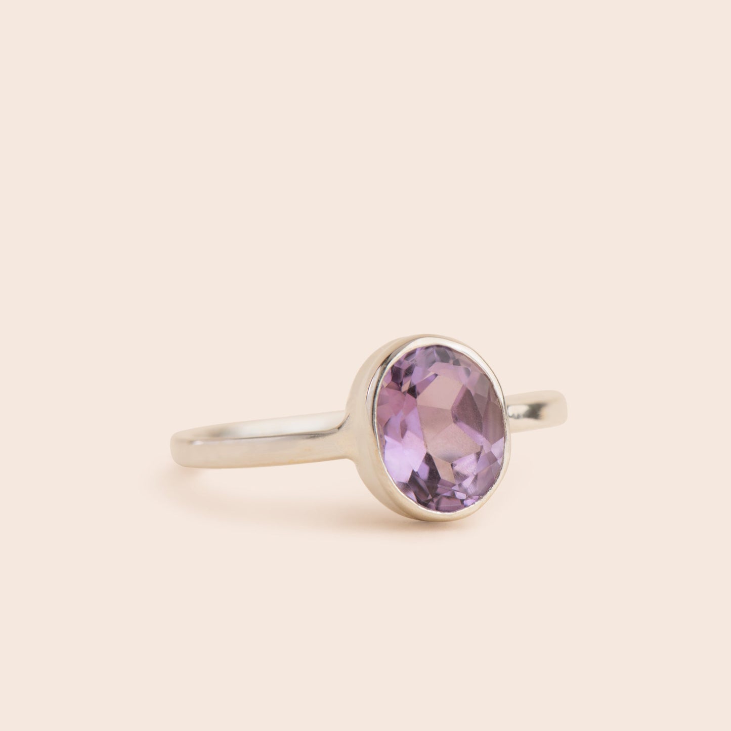 Luminous amethyst stone set in an oval shape on a gleaming sterling silver band, a timeless piece of jewelry to add to your collection.